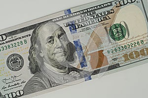 100 Dollars bill and portrait Benjamin Franklin on USA money banknote. Hundred dollar bills on wooden background