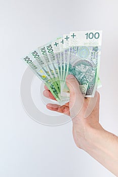 100 EUR and 100 PLN banknotes held in right hand