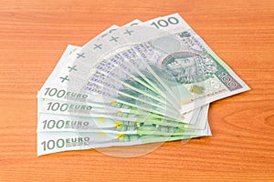 100 EUR and 100 PLN banknotes on wooden table