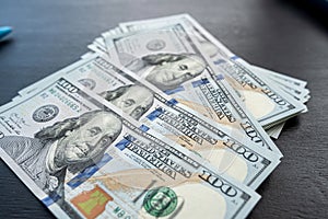 100 new US dollar bills on black background
