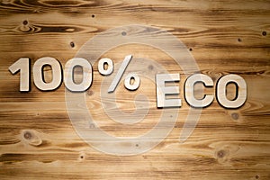 100 percent ECO words made of wooden block letters on wooden board