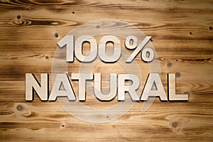 100 percent NATURAL words made of wooden block letters on wooden board