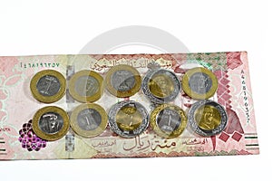 100 SAR one hundred Saudi Arabia riyals cash money banknote with pile of Saudi riyal coins 1 and 2 riyals features king Salman Bin
