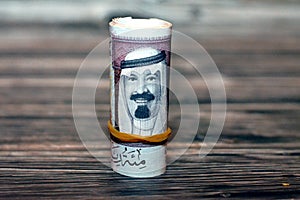 100 SAR one hundred Saudi riyals cash money banknote bills rolled up with rubber bands with the photo of king Abdullah