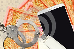 100 Sri Lankan rupees bills and smartphone with police handcuffs. Concept of hackers phishing attacks, illegal scam or malware