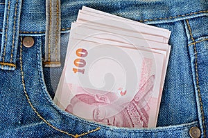 100 thai banknotes in men' s blue jeans pocket