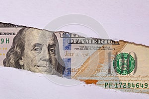 100 US dollar banknote in torn paper hole