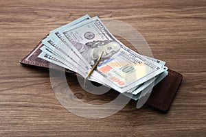 100 US Dollar bills stack on wooden table