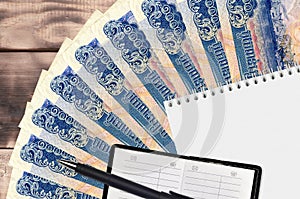 1000 Cambodian riels bills fan and notepad with contact book and black pen. Concept of financial planning and business strategy