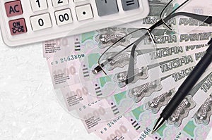 1000 russian rubles bills fan and calculator with glasses and pen. Business loan or tax payment season concept