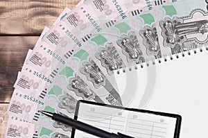 1000 russian rubles bills fan and notepad with contact book and black pen. Concept of financial planning and business strategy
