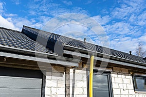 100mm diameter yellow PVC pipe connected to the end of the gutter on the roof, protected against water.