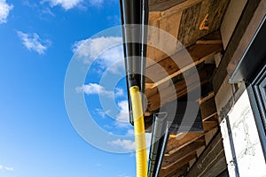 100mm diameter yellow PVC pipe connected to the end of the gutter on the roof, protected against water.