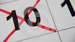 The 10st number in the calendar is crossed out with a red cross in a macro on a white sheet. Calendar for plans, notes
