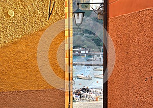 11.04.2018. colorful wall of old buildings and narrow view on Portofino beach with people and sea in Liguria, italy