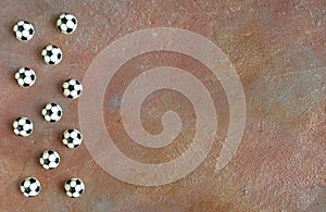 11 football players in the form of balls on the field background. The balls are made of milk chocolate - the concept of a