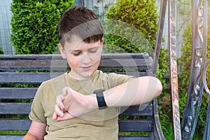 An 11-year old teenager looking at the time in his smart watch, a close-up