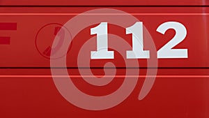 The 112 phone number on a red background