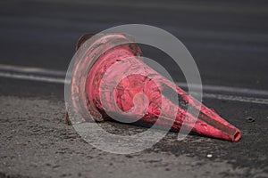 12-05-2022 Riga, Latvia a red cone laying on the side of a road next to a street sign and a street sign that says