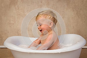 12 month old boy splashing in tub