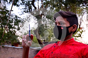 13 years old Asian cute boy wearing protective mask, with syringe, prevention of Corona virus Covid -19 and pollution