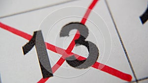 The 13st number in the calendar is crossed out with a red cross in a macro on a white sheet. Calendar for plans, notes