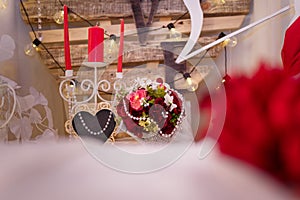 14 February Valentine`s day concept. Romantic flowers and heart frame on wooden background with bulb lamps.