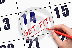 14th day of the month. Hand writing text GET FIT and drawing a line on calendar date. Save the date.