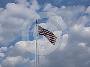 15 Star USA Flag called the Star Spangled Banner flies unfurled with cumulus clouds and blue sky in the background