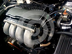 A 1500 cc car engine with four inlet of air manifold. Photo was taken during car service