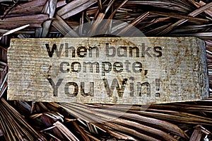 158 Text when banks compete you win on wood texture and fan palm leaf background