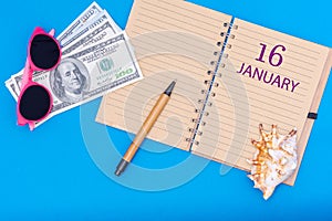 16th day of January. Travel plan flat design with notepad written date, pen, glasses, money dollars and seashell