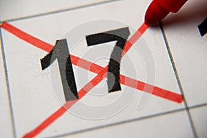 The 17st number in the calendar is crossed out with a red cross in a macro on a white sheet. Calendar for plans, notes