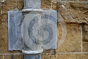 17th Century Lead downpipe detail on a yellow ironstone wall. England, UK.