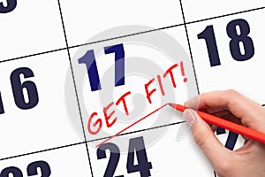17th day of the month. Hand writing text GET FIT and drawing a line on calendar date. Save the date.