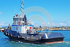 An 18 meter Commercial Tug Boat under way in Gladstone Marina Harbour. Queensland, Australia