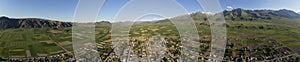 180 degree aerial panorama of village, farms, and mountains in Kyrgyzstan
