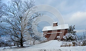 18th Century weathered red barn with cupola in winter