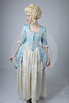 18th century woman with a blonde wig and blue gown