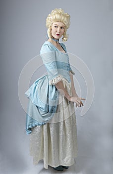 18th century woman with a blonde wig and blue gown