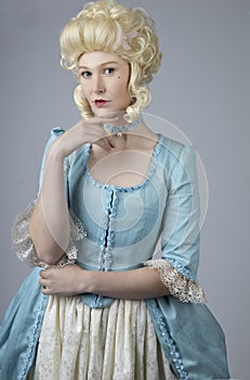 18th century woman with a blonde wig and blue gown