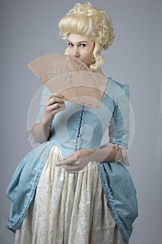 18th century woman with a blonde wig and blue gown