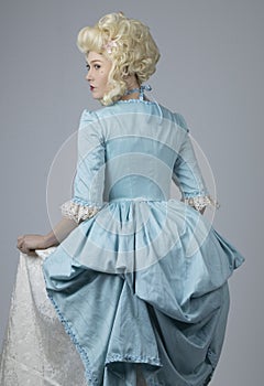 18th century woman with a blonde wig and blue gown