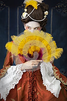 An 18th-Century woman wearing a robe a la Francaise and holding a fan.