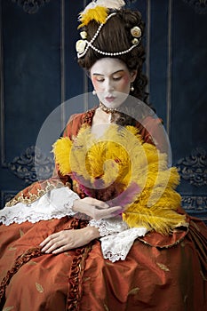 An 18th-Century woman wearing a robe a la Francaise and holding a fan.