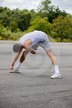 A 19 Year Old Teenage Boy Stretching In A Public Park