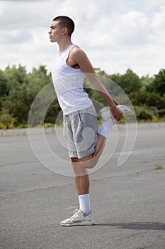 A 19 Year Old Teenage Boy Stretching In A Public Park