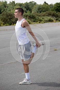 A 19 Year Old Teenage Boy Stretching In A Public Park