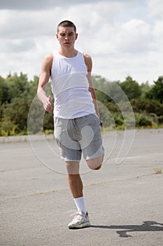 A 19 Year Old Teenage Boy Stretching In A Public Park