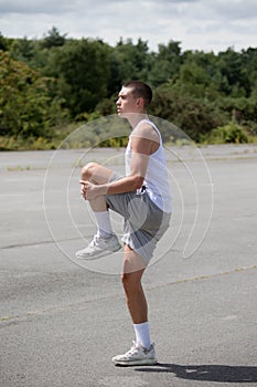 A 19 Year Old Teenage Boy Stretching In A Public Park